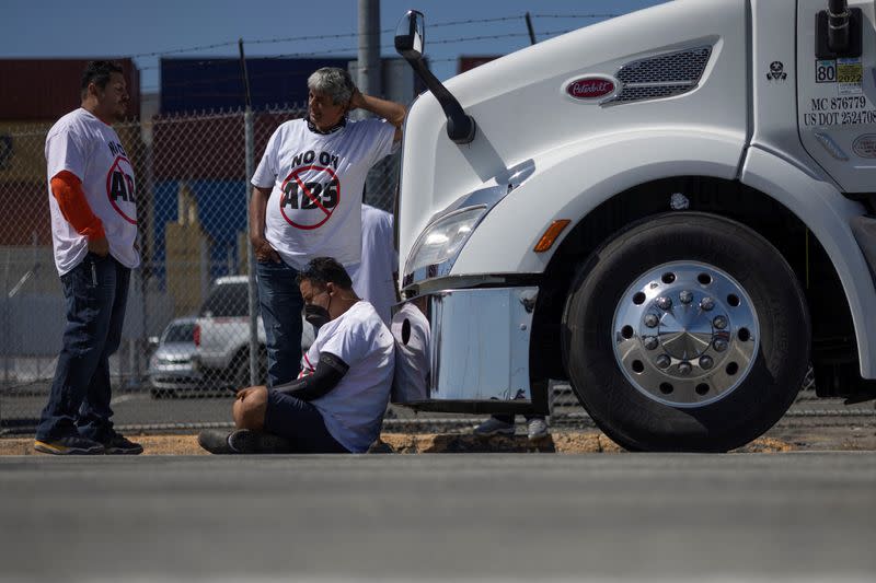 Independent truck drivers gather to delay the entry of trucks at a container terminal at the Port of Oakland, during a protest against California's law known as AB5, in Oakland, California