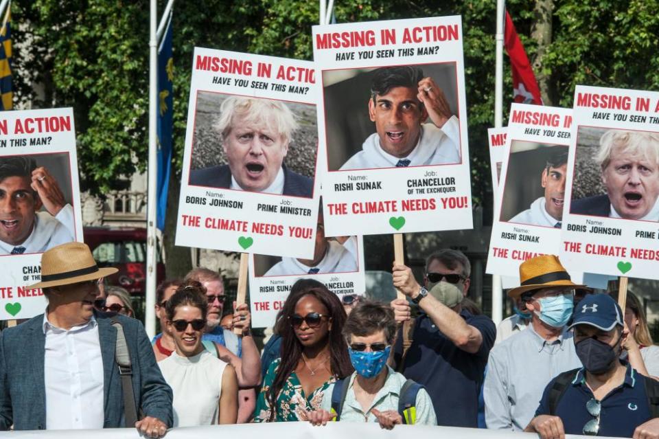 Activists hold banners and placards in Parliament Square, London, to mark 100 days until Cop26