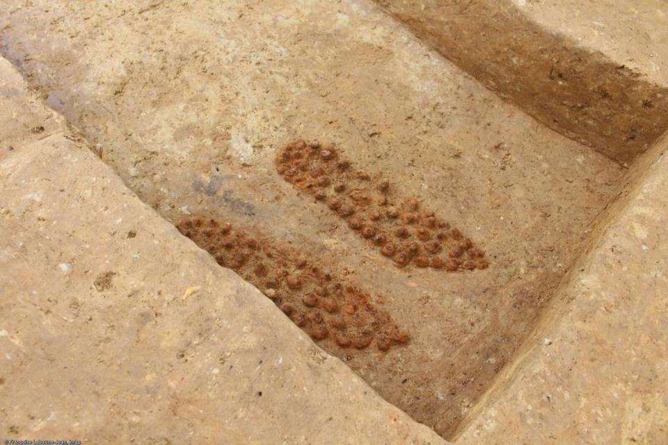 The soles of a pair of studded shoes left in a tomb.