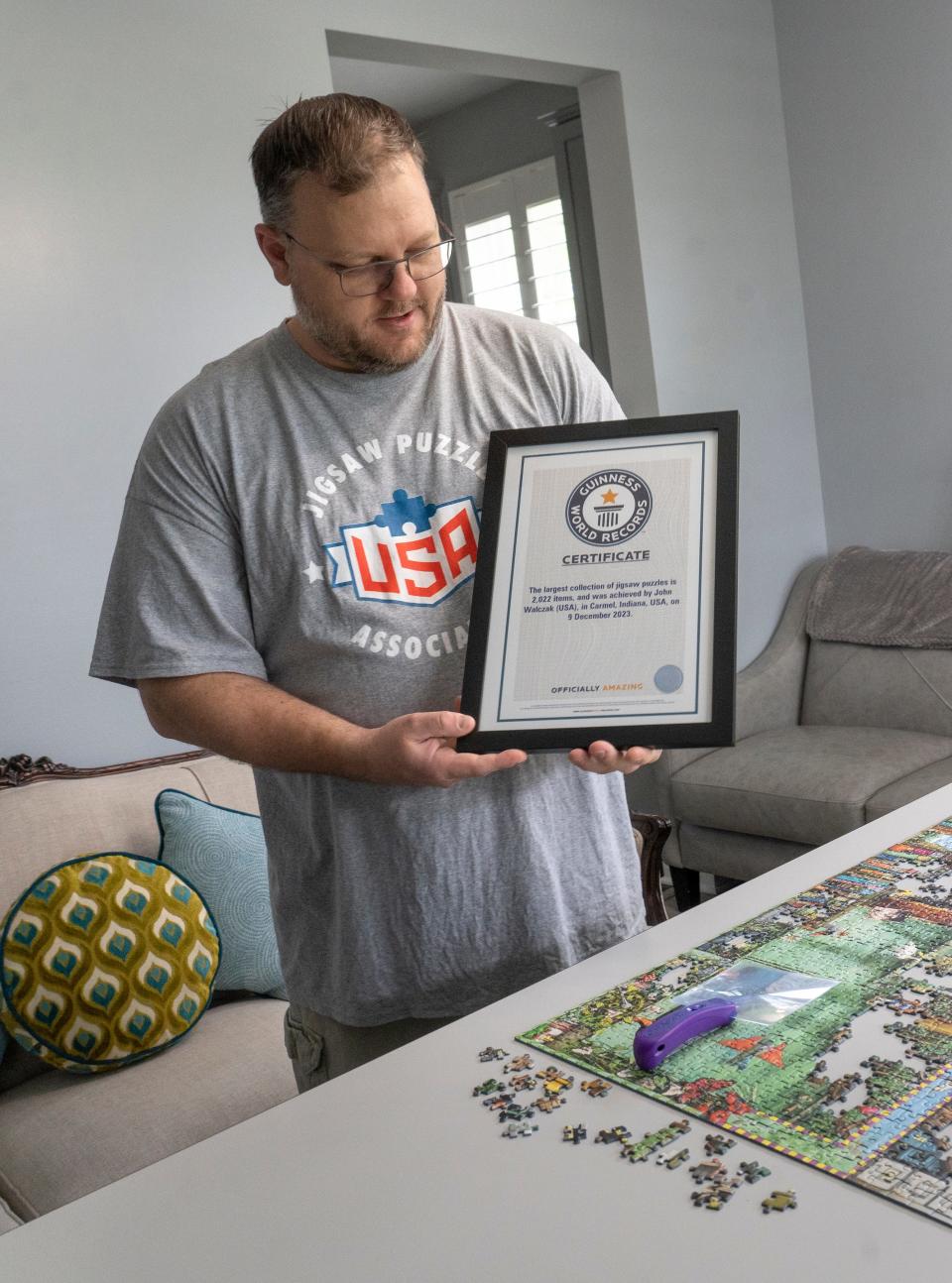 John Walczak shows the certificate he received when he recently achieved a Guinness World Record for the largest collection of jigsaw puzzles. Photo taken Friday, May 3, 2024 in his Carmel home.