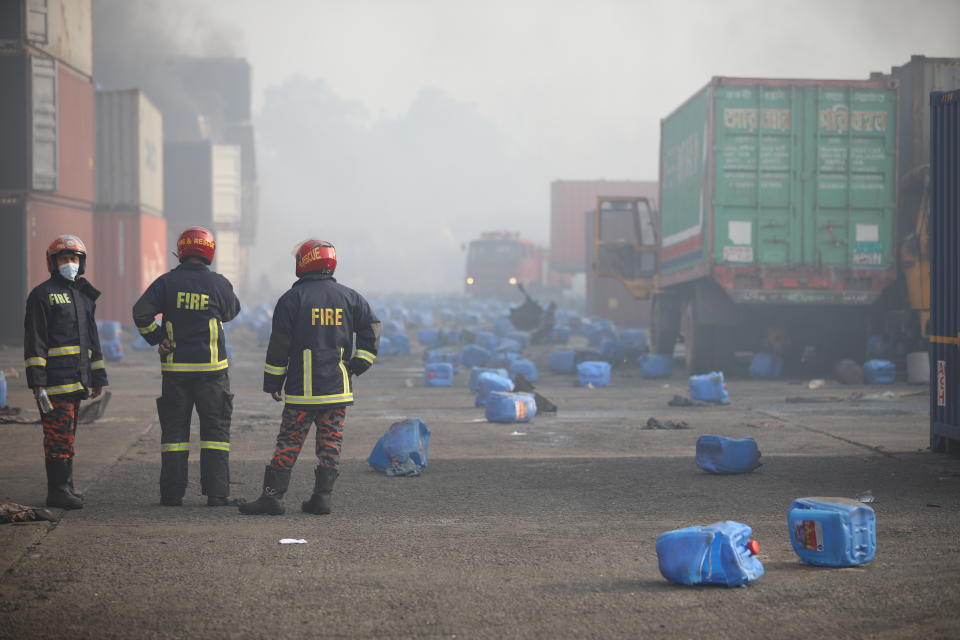 Firefighters look on after a fire broke out at the BM Inland Container Depot, a Dutch-Bangladesh joint venture, in Chittagong, 216 kilometers (134 miles) southeast of capital, Dhaka, Bangladesh, early Sunday, June 5, 2022. Several people were killed and more than 100 others were injured in the fire the cause of which could not be immediately determined. (AP Photo)