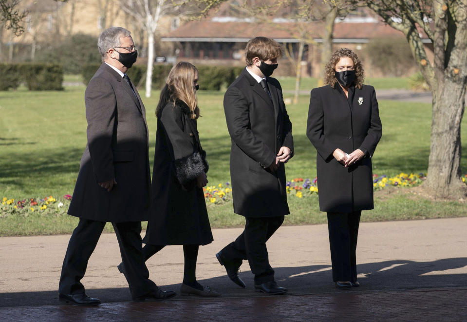 The family of Captain Tom Moore, from left, son-in-law Colin Ingram, granddaughter Georgia, grandson Benjie and daughter Hannah Ingram-Moore arrive for his funeral, at Bedford Crematorium, in Bedford, England, Saturday, Feb. 27, 2021. Tom Moore, the 100-year-old World War II veteran who captivated the British public in the early days of the coronavirus pandemic with his fundraising efforts died, Tuesday Feb. 2, 2021. (Joe Giddens/Pool Photo via AP)