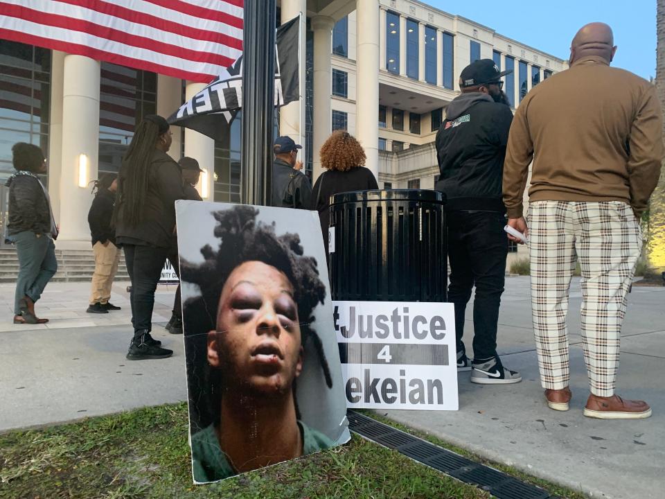 A sign showing Le'Keian Woods' injuries after police used force to arrest him stands near protesters at a Jacksonville Community Action Committee rally on Nov. 30 in front of the Duval County Courthouse.