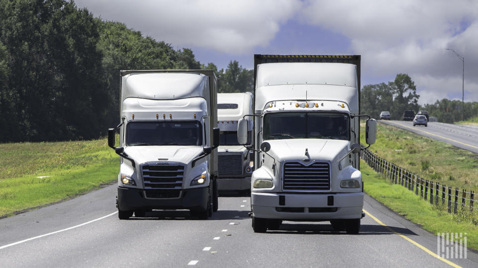 White tractors pulling trailers on a highway