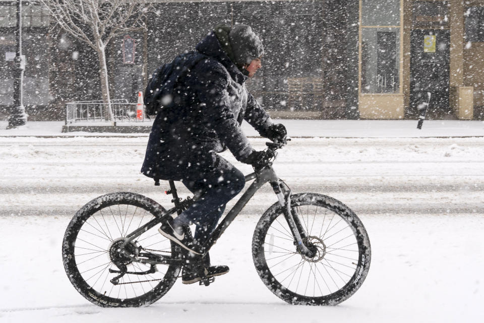 Corey Bayrd rides his bike to a grocery store during a heavy snowfall, Tuesday, March 14, 2023, in Brunswick, Maine. (AP Photo/Robert F. Bukaty)