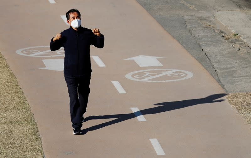 A man wearing a mask following the rise in confirmed cases of coronavirus disease (COVID-19), takes a walk at a park in Daegu