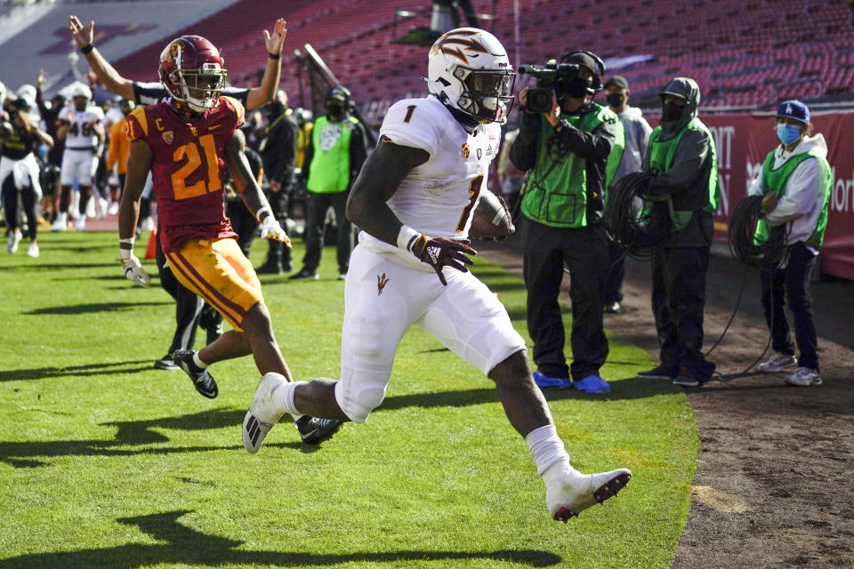 Arizona State running back Chip Trayanum (1) scores a touchdown ahead of Southern California safety Isaiah Pola-Mao (21) during the first half of an NCAA college football game Saturday, Nov. 7, 2020, in Los Angeles. (AP Photo/Ashley Landis)