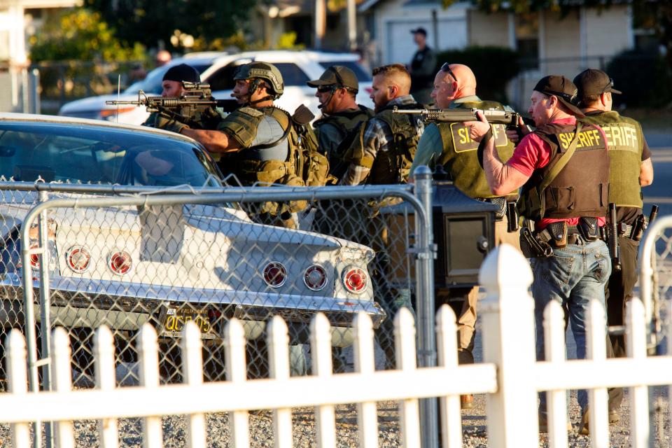 Law enforcement officers search for the suspects of a mass shooting  Dec. 2, 2015 in San Bernardino, Calif.  A man and a woman suspected of carrying out a deadly shooting at a center for the disabled were killed in a shootout with police, while a third person was detained, police said.   