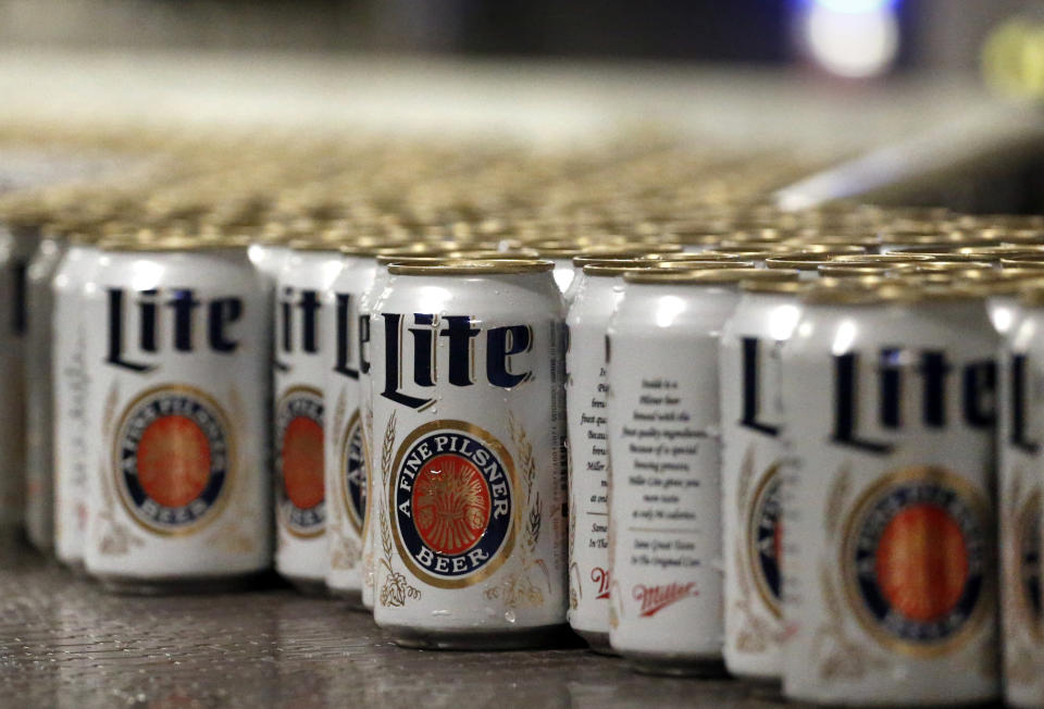 FILE - In this March 11, 2015 file photo, newly-filled and sealed cans of Miller Lite beer move along on a conveyor belt, at the MillerCoors Brewery, in Golden, Colo. A Wisconsin judge on Friday, May 24, 2019, ordered Anheuser-Busch to stop suggesting in advertising that MillerCoors' light beers contain corn syrup, wading into a fight between two beer giants that are losing market share to small independent brewers. (AP Photo/Brennan Linsley, File)