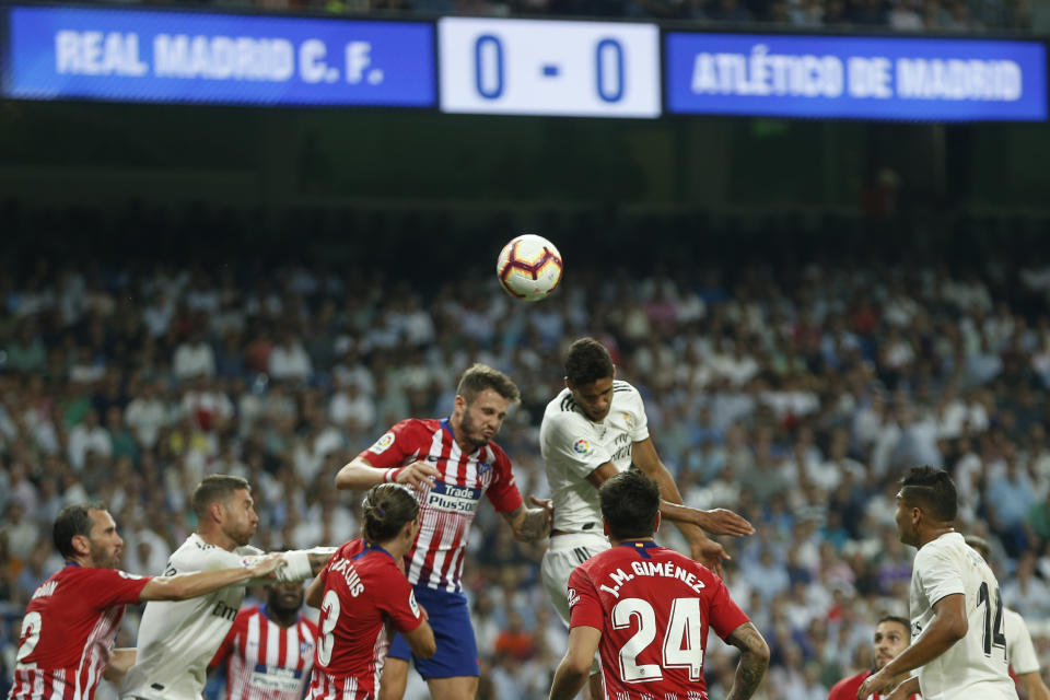 Real Madrid's Raphael Varane, top right, goes for a header with Atletico Madrid's Saul Niguez, top left, during a Spanish La Liga soccer match between Real Madrid and Atletico Madrid at the Santiago Bernabeu stadium in Madrid, Spain, Saturday, Sept. 29, 2018. The match ended in a 0-0 draw. (AP Photo/Paul White)