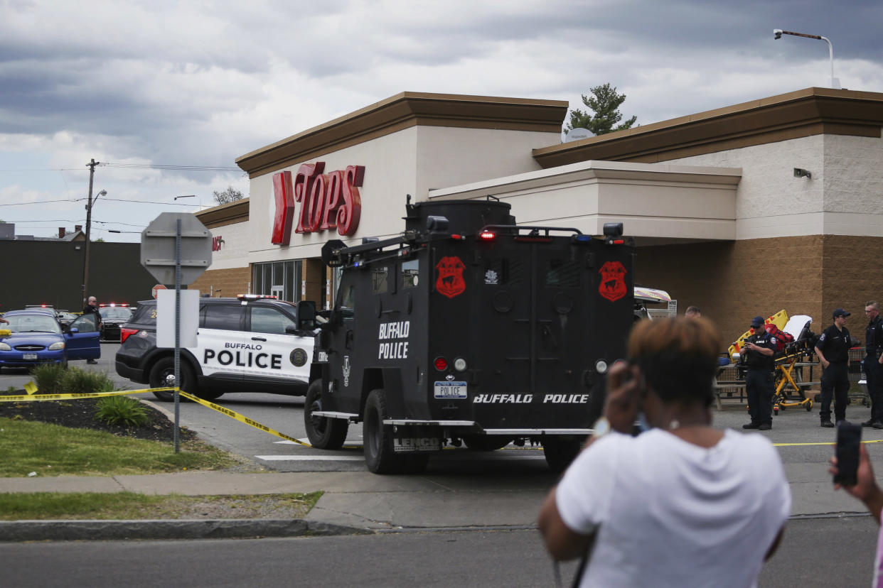 Image: A crowd gathers as law enforcement investigates the scene of a mass shooting at a Tops supermarket in Buffalo, N.Y., on Saturday. (Joshua Bessex / AP)