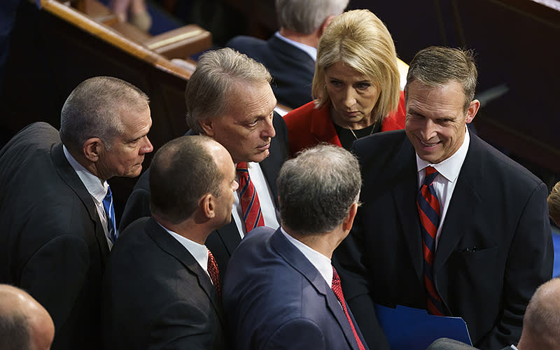 Reps. Matt Rosendale (R-Mont.), left; Bob Good (R-Va.), center right; Andy Biggs (R-Ariz.), top center; Andrew Clyde (R-Ga.), center left; Mary Miller (R-Ill.), top right; and Scott Perry (R-Pa.), right, are seen following the Speaker vote during the first day of the 118th session of Congress on Jan. 3. <em>Greg Nash</em>