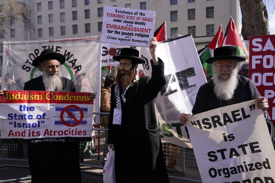 Protestors show placards during the visit of Israeli Prime Minister Benjamin Netanyahu to 10 Downing Street in London, Friday, March 24, 2023.(AP Photo/Alberto Pezzali)