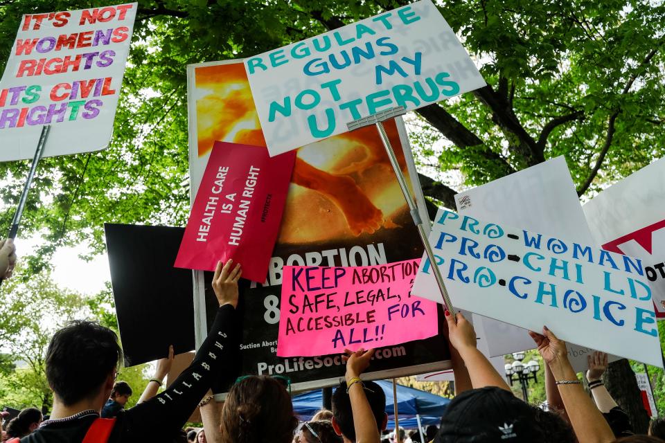 Abortion rights activists use their signs to cover anti-abortion activists' signs during a Bans Off Our Bodies protest at U-M's Diag in Ann Arbor on Saturday, May 14, 2022.