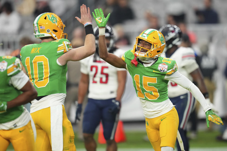 Oregon wide receiver Tez Johnson (15) celebrates his touchdown with quarterback Bo Nix (10) during the second half on the NCAA Fiesta Bowl college football game against Liberty, Monday, Jan. 1, 2024, in Glendale, Ariz. Oregon defeated Liberty 45-6. (AP Photo/Ross D. Franklin)