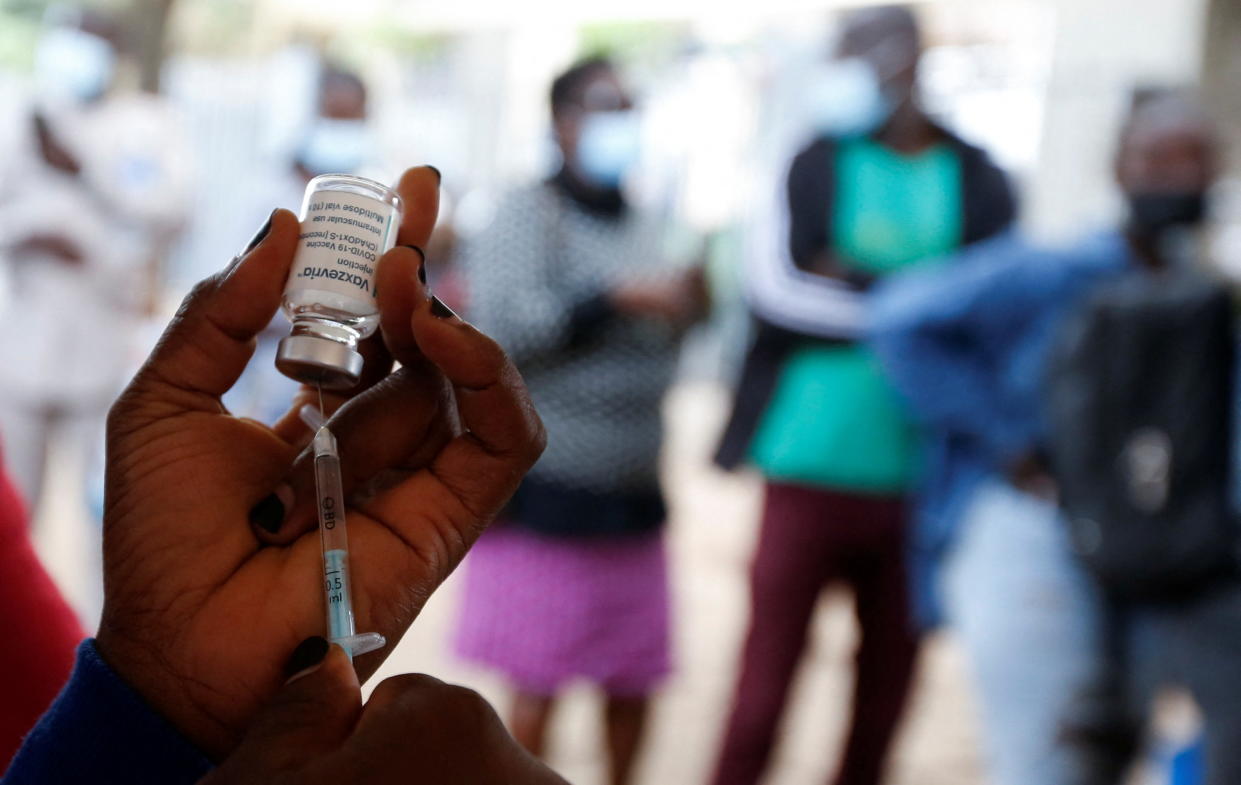 A health-worker holds a syringe and vaccine vial before administering the coronavirus disease (COVID-19) vaccine to civilians at a makeshift tent as the government orders for proof of vaccination to access public places and transport, in downtown Nairobi, Kenya December 23, 2021. REUTERS/Monicah Mwangi