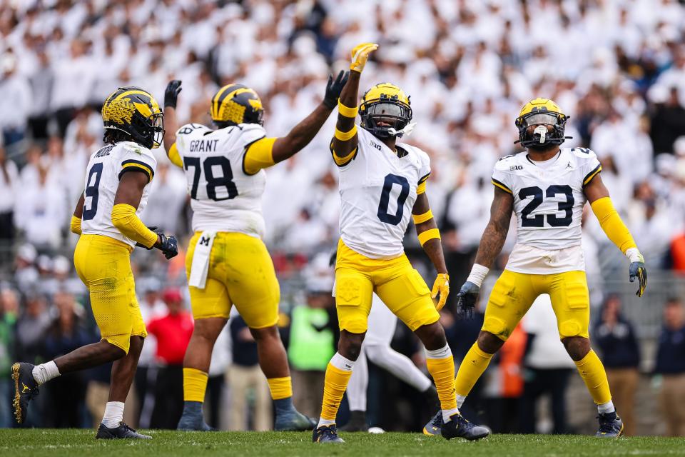 Rod Moore, Kenneth Grant, Mike Sainristil, and Michael Barrett of the Michigan Wolverines react to a play against the Penn State Nittany Lions during the first half at Beaver Stadium on November 11, 2023 in State College, Pennsylvania.