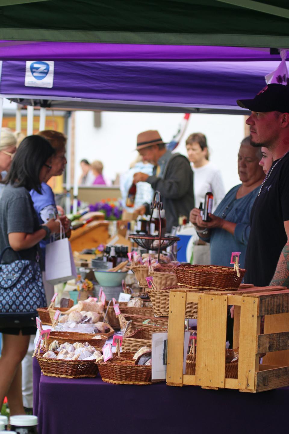 People enjoy shopping at the Charlevoix Farmers Market during the Venetian Festival on Thursday, July 22.