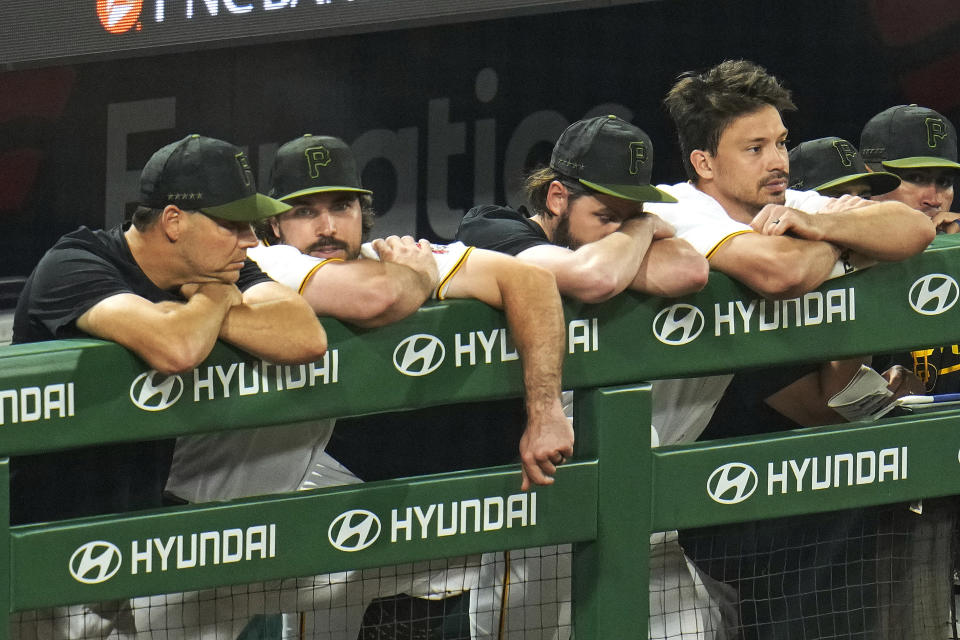 From left to right, Pittsburgh Pirates' Rich Hall, Austin Hedges, J.T. Brubaker and Bryan Reynolds stand in the dugout during the ninth inning of a baseball game against the Cleveland Guardians in Pittsburgh, Monday, July 17, 2023. (AP Photo/Gene J. Puskar)