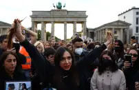 <p>A demonstrator holds hair during a protest following the death of Mahsa Amini, in front of the Brandenburg Gate in Berlin, Germany, September 23, 2022. REUTERS/Christian Mang</p> 