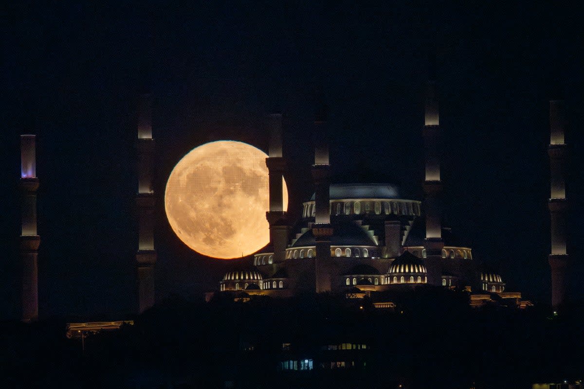 The Sturgeon full moon rises behind Istanbul's Camlica Mosque on August 01, 2023 in Istanbul, Turkey (Getty Images)