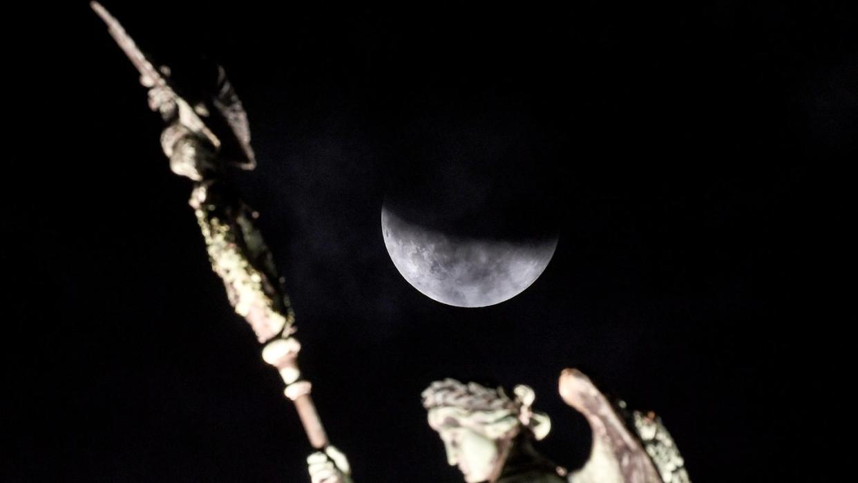 Der Mond ist während der partiellen Mondfinsternis hinter der Quadriga des Brandenburger Tors zu sehen. Foto: Britta Pedersen