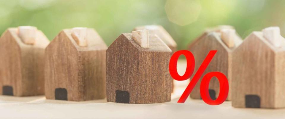 Small wooden houses with red percent sign, symbolizing mortgage rates