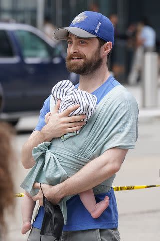 <p>Kristin Callahan/Shutterstock</p> Daniel Radcliffe holding his infant son