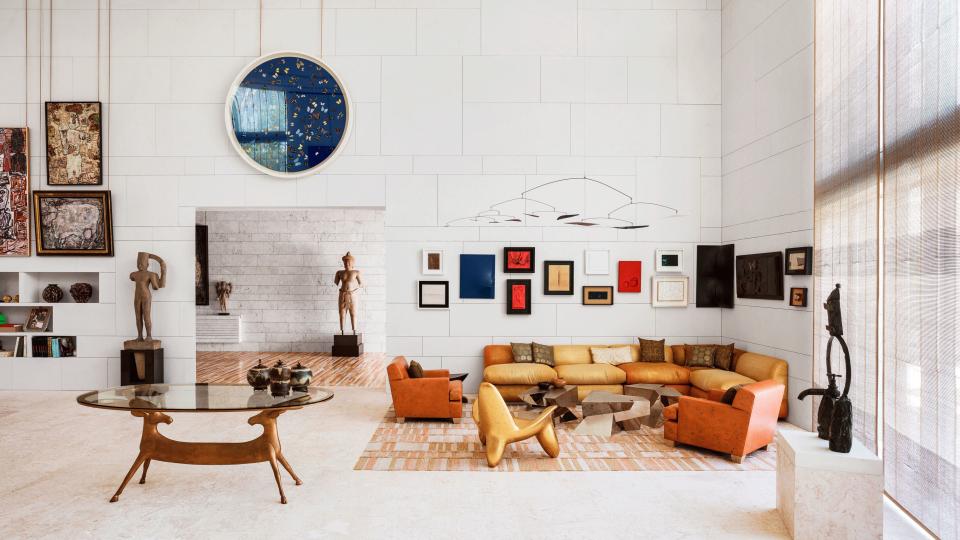 Highlights in the art-filled living room include a work by Damien Hirst (above doorway) and an Alexander Calder mobile. The room also features (from left) a Claude Lalanne table, a custom sofa and armchairs by Peter Marino Architect, a Wendell Castle chair, and a cocktail table by Juan and Paloma Garrido. Damien Hirst artwork © Damien Hirst and Science Ltd. All rights reserved/DACS, London/ARS, NY 2018. Alexander Calder mobile © 2019 Calder Foundation, New York/Artists Rights Society (ARS), New York.