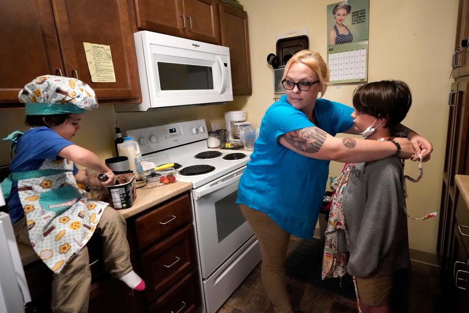 In this July 28, 2021 photo, Christina Darling and her sons, Brennan, 4, left, and Kayden, 10, prepare a snack at home in Nashua, N.H. Darling and her family have qualified for the expanded child tax credit, part of President Joe Biden's $1.9 trillion coronavirus relief package. "Every step closer we get to a livable wage is beneficial. That is money that gets turned around and spent on the betterment of my kids and myself," said Darling, a housing resource coordinator who had been supplementing her $35,000-a-year salary with monthly visits to the Nashua Soup Kitchen and Shelter's food pantry. (AP Photo/Elise Amendola) ORG XMIT: NHEA202