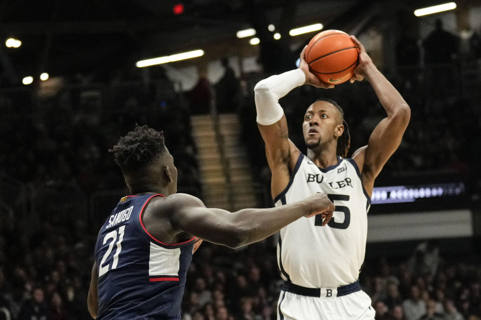 Butler center Manny Bates, right, shoots over Connecticut forward Adama Sanogo in the first half of an NCAA college basketball game in Indianapolis, Saturday, Dec. 17, 2022. (AP Photo/AJ Mast)