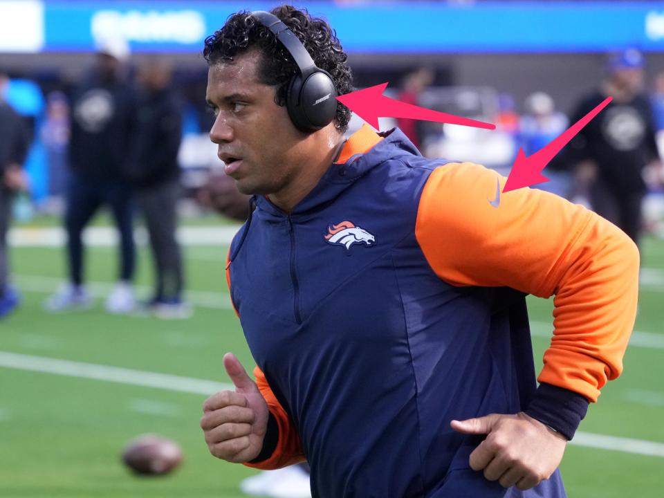 Russell Wilson runs onto the field in Bose headphones and a Nike sweatshirt.