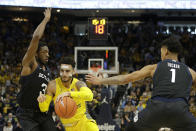 Marquette's Markus Howard drives to the basket between Butler's Kamar Baldwin (3) and Jordan Tucker (1) during the first half of an NCAA college basketball game Sunday, Feb. 9, 2020, in Milwaukee. (AP Photo/Aaron Gash)