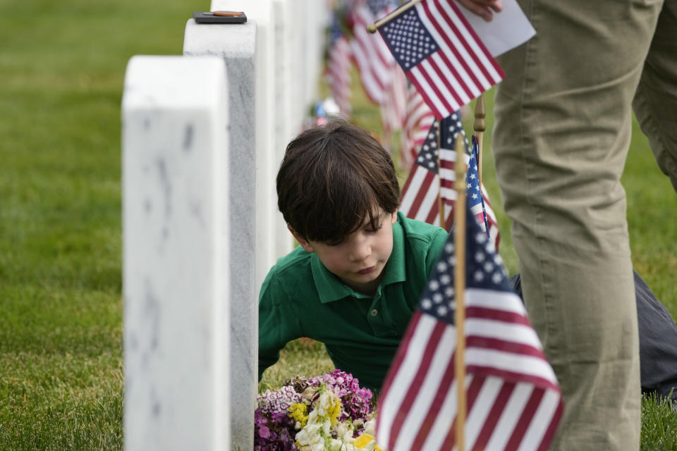 Raphael Michel, 7, of Washington, visits the grave of a soldier that his father served with in Section 60 at Arlington National Cemetery on Memorial Day, Monday, May 29, 2023, in Arlington, Va. (AP Photo/Alex Brandon)