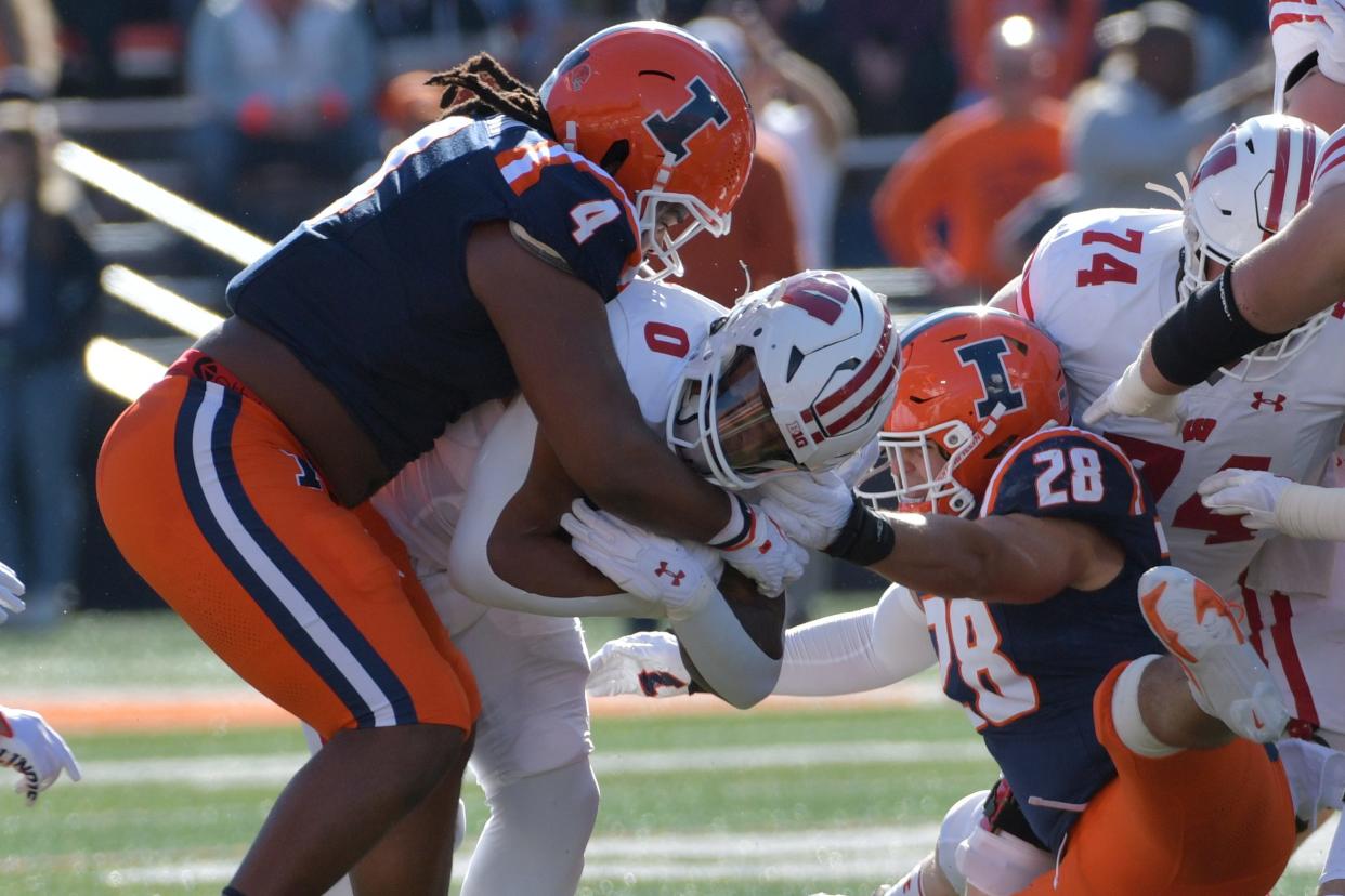 Oct 21, 2023; Champaign, Illinois, USA; Illinois Fighting Illini defensive tackle Jer'Zhan Newton (4) tackles Wisconsin Badgers running back Braelon Allen (0) during the first half at Memorial Stadium. Mandatory Credit: Ron Johnson-USA TODAY Sports