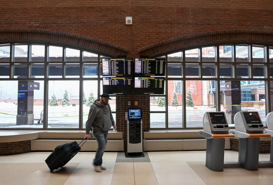 Travelers at The Albany International Airport make arrangements after their flights were canceled during a winter snow storm Tuesday, March 14, 2023, in Albany, N.Y. (AP Photo/Hans Pennink)