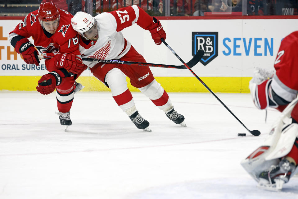 Detroit Red Wings' David Perron (57) tangles with Carolina Hurricanes' Brady Skjei (76) during the first period of an NHL hockey game in Raleigh, N.C., Tuesday, April 11, 2023. (AP Photo/Karl B DeBlaker)