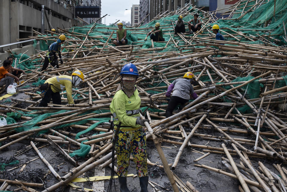 颱風過後，工人移除倒塌的竹藤棚架，該棚架堵塞街道，類似情況各區可見。 (Photo by Miguel Candela/SOPA Images/LightRocket via Getty Images)