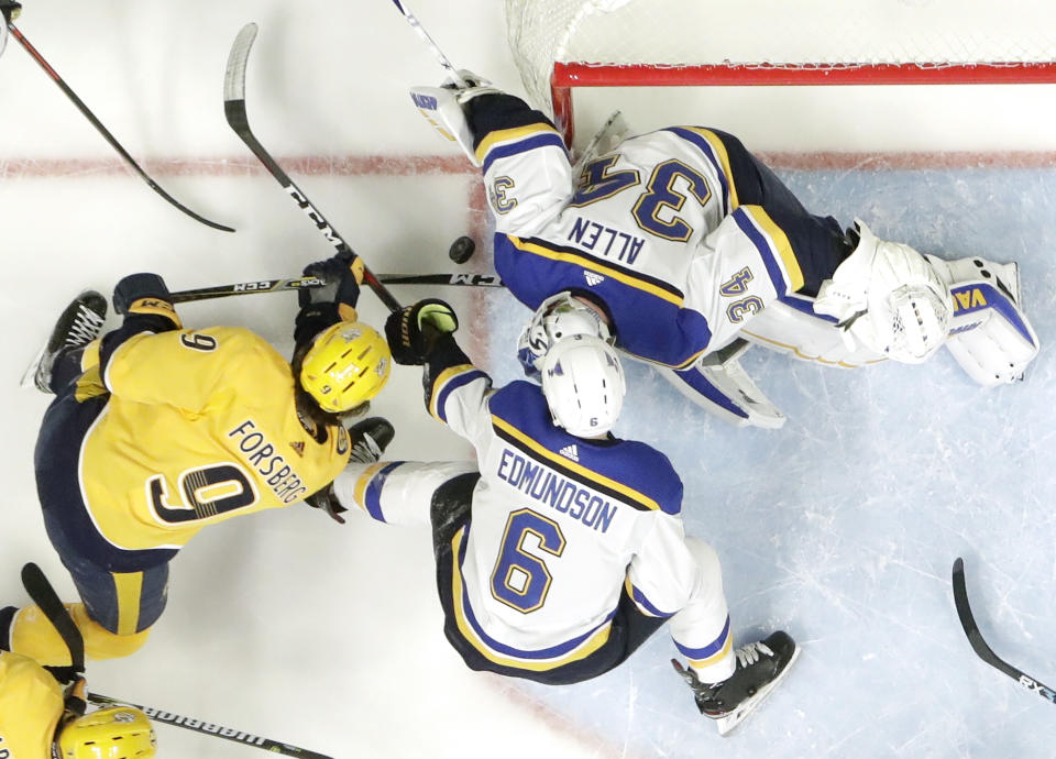 St. Louis Blues goaltender Jake Allen (34) blocks a shot by Nashville Predators left wing Filip Forsberg (9), of Sweden, in the first period of an NHL hockey game Sunday, Feb. 10, 2019, in Nashville, Tenn. Also defending for the Blues is Joel Edmundson (6). (AP Photo/Mark Humphrey)