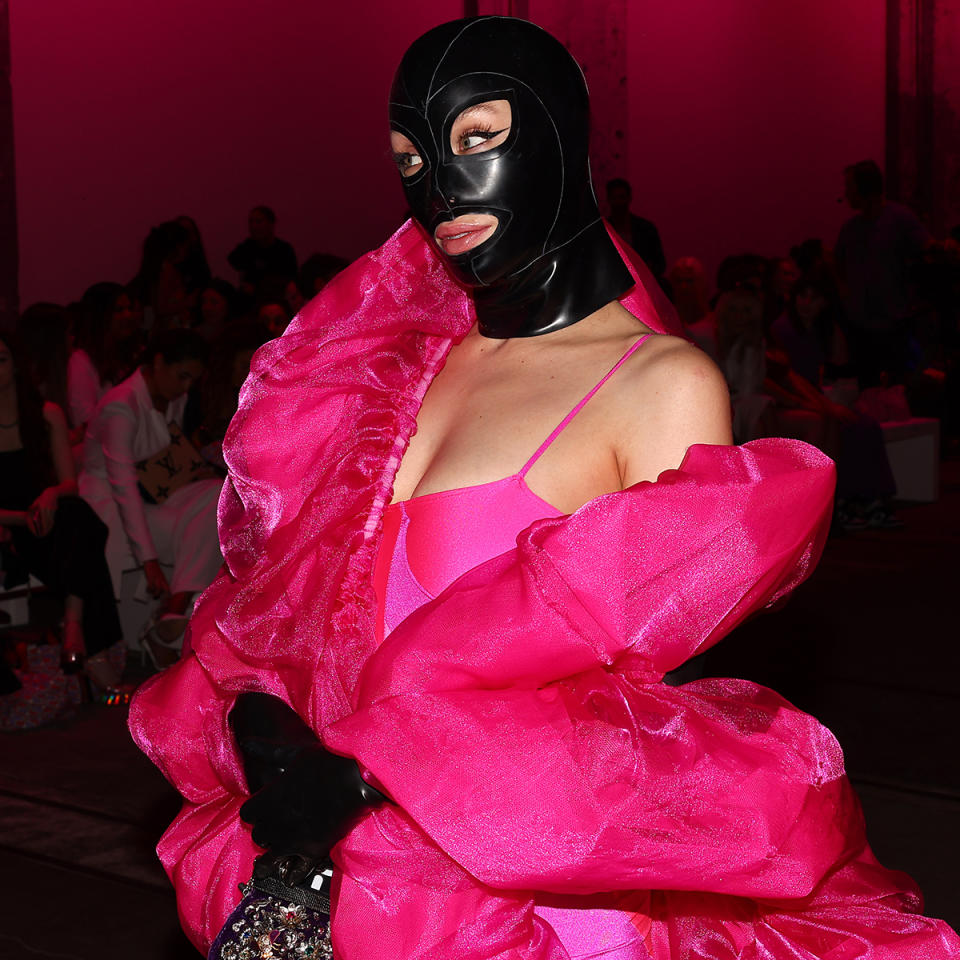 Imogen Anthony wearing a black gimp mask with a hot pink outfit. 