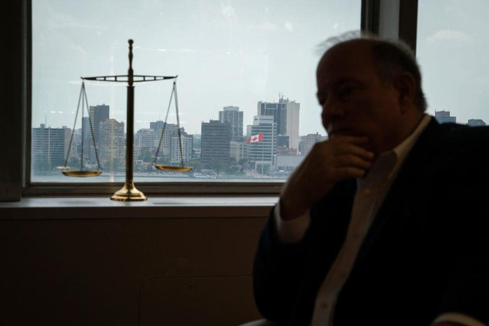 A view of the Canadian skyline is seen through a window as Detroit Mayor Mike Duggan sits for an interview with a Free Press reporter at his office in downtown Detroit on Thursday, Aug. 10, 2023.