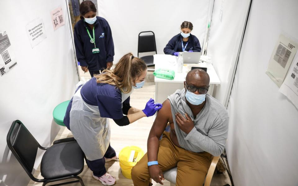 A man receives a dose of the Pfizer Covid shot at a vaccination site at the Westfield shopping centre - EUTERS/Henry Nicholls