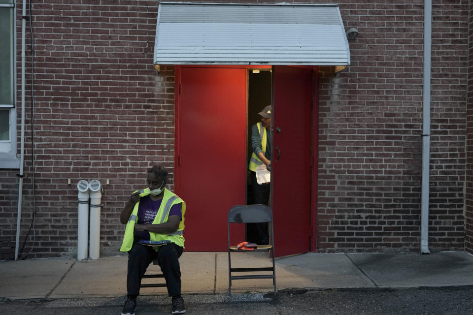 Karen Hull, left, and Reginald Rawls wait for vehicles to arrive at the entrance into the Calvary Baptist Church parking lot which is located near the Philadelphia Union's Subaru Park prior to a soccer game, Wednesday, Oct. 4, 2023, in Chester, Pa. (AP Photo/Michael Perez)