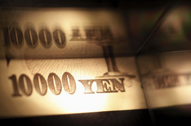 Light is cast on a Japanese 10,000 yen note as it's reflected in a plastic board in Tokyo, in this February 28, 2013 picture illustration. REUTERS/Shohei Miyano/Files