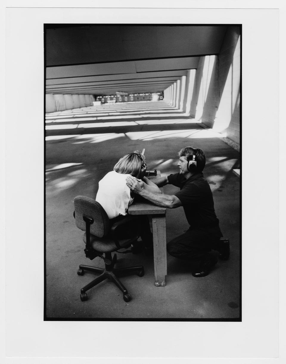 Firing a US Secret Service sniper rifle at a water-filled jug while touring the Secret Service training center in Beltsville, Maryland. The jug can be seen exploding down-range. October 4, 1997.&nbsp;