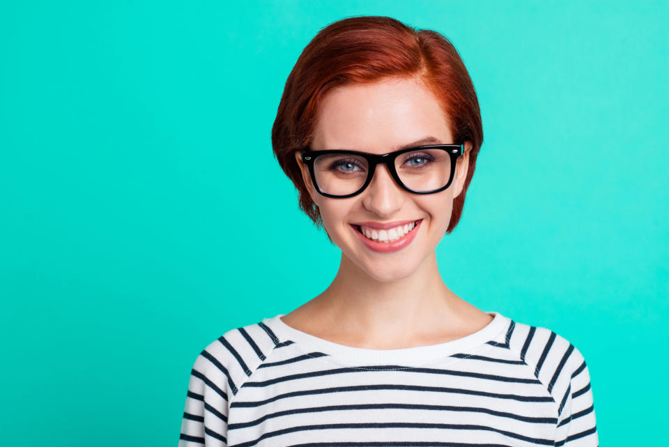 A smiling short-haired young woman in glasses.