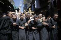 Christian worshippers lock arms during a procession along the Via Dolorosa on Good Friday during Holy Week in Jerusalem's Old City April 18, 2014. Christian worshippers on Friday retraced the route Jesus took along Via Dolorosa to his crucifixion in the Church of the Holy Sepulchre. Holy Week is celebrated in many Christian traditions during the week before Easter.