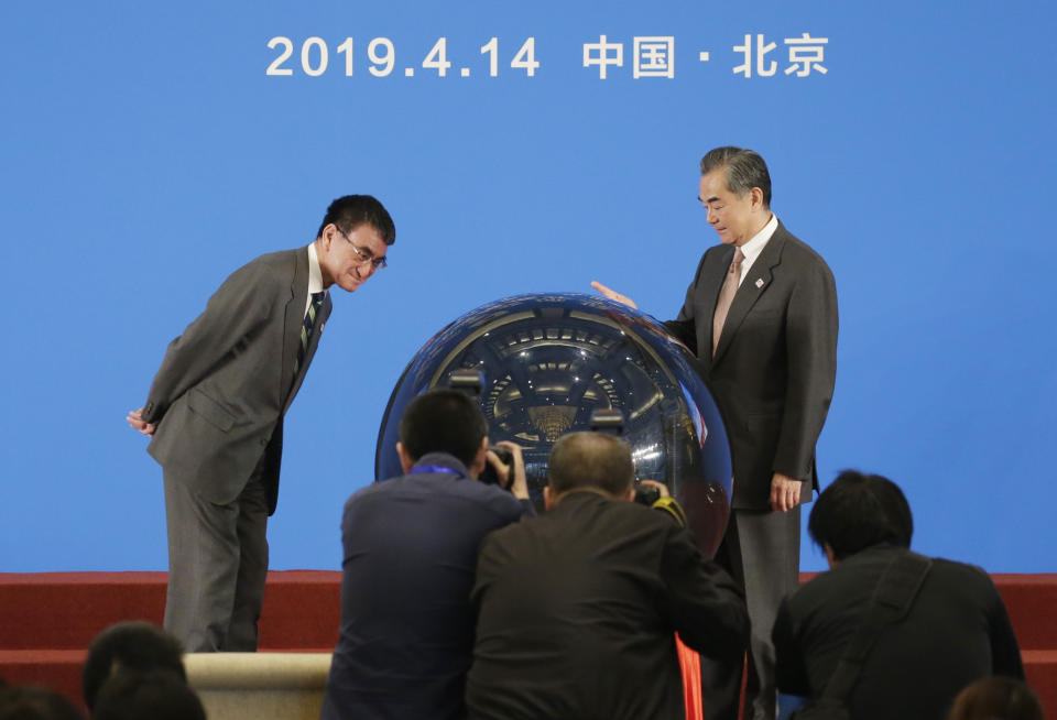 Japanese Foreign Minister Taro Kono, left, and China's Foreign Minister Wang Yi, right, attend an opening ceremony for the Japan-China year of youth exchange at Diaoyutai State Guesthouse in Beijing, China, Sunday, April 14, 2019.(Jason Lee/Pool Photo via AP)