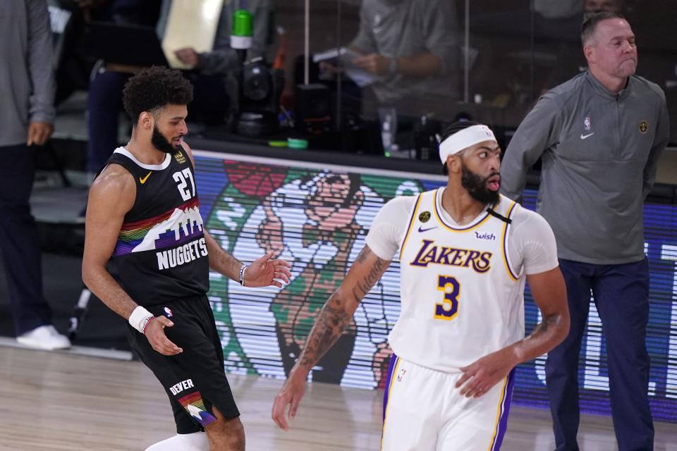 Denver Nuggets' Jamal Murray (27) celebrates sinking a 3-point basket as Los Angeles Lakers' Anthony Davis (3) and head coach Michael Malone, right rear, look on during the second half of Game 3 of the NBA basketball Western Conference final Tuesday, Sept. 22, 2020, in Lake Buena Vista, Fla. (AP Photo/Mark J. Terrill)