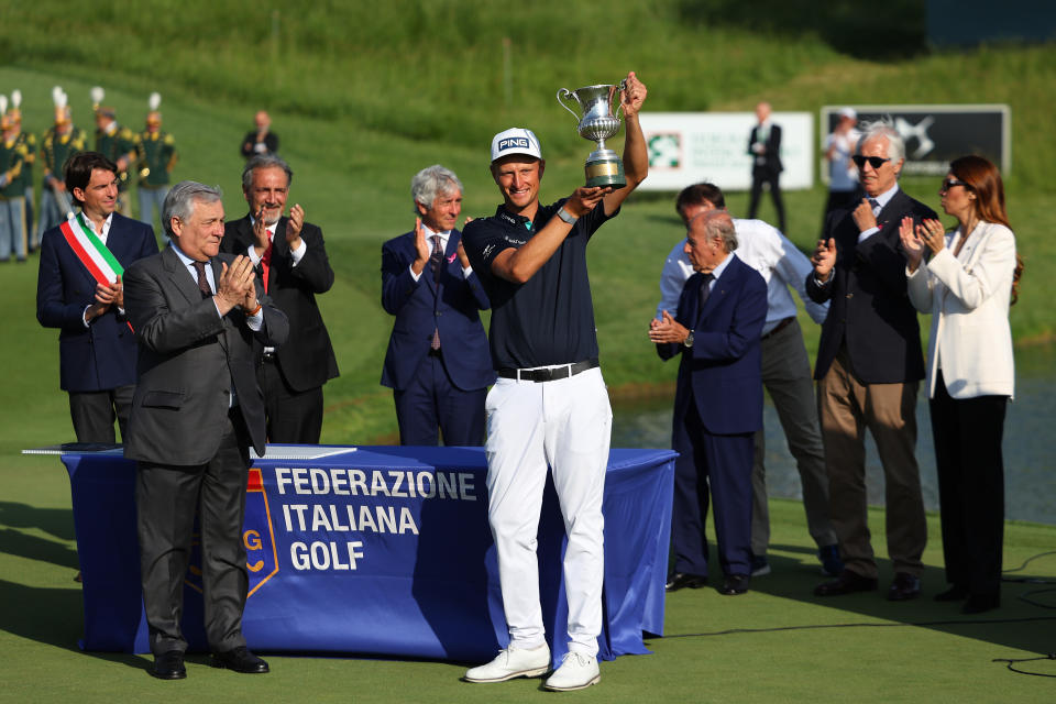 Adrian Meronk lifts the trophy in front of a crowd